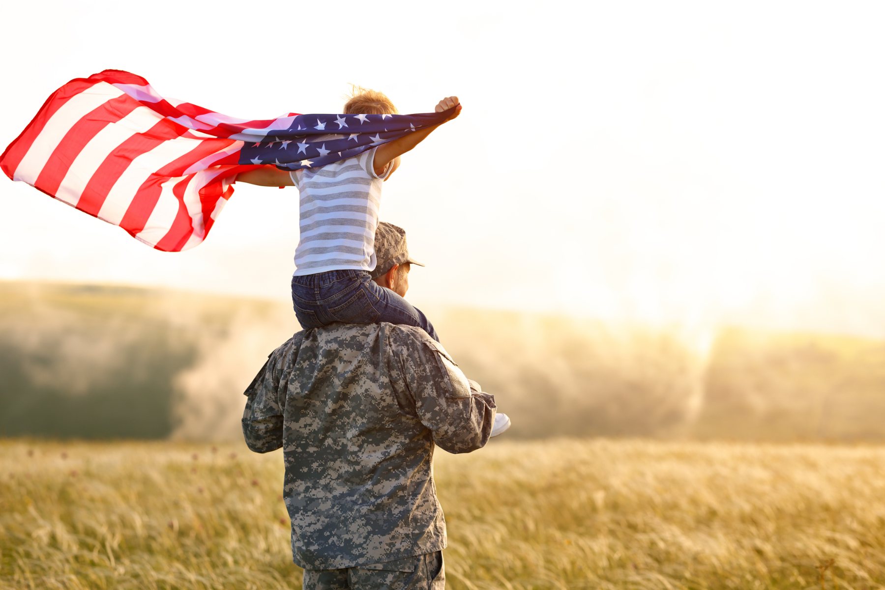 A veteran and child holding a United States flag